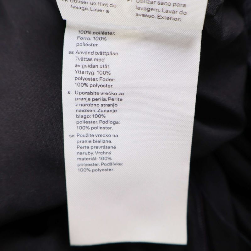 Materiallapp visar 100 procent polyester på byxorna