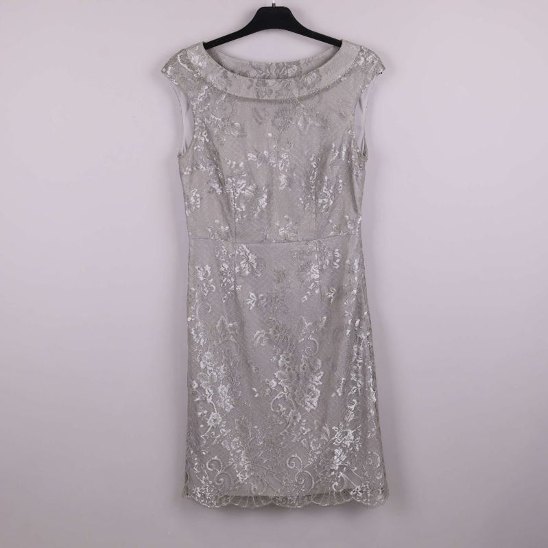 Silverfärgad spetsklänning sedd framifrån på galge