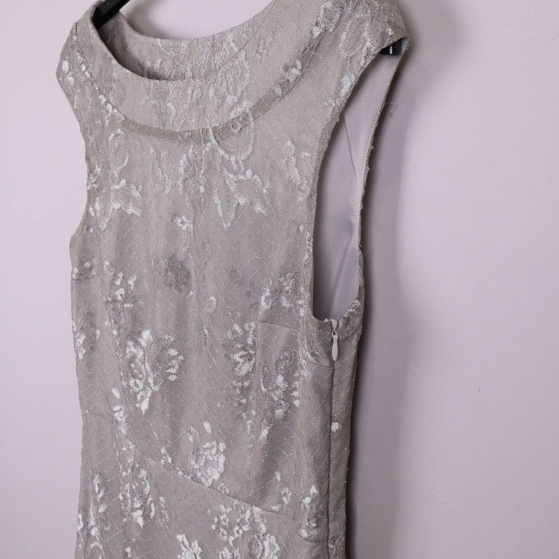 Sned närbild på axel och överdel av silverfärgad spetsklänning