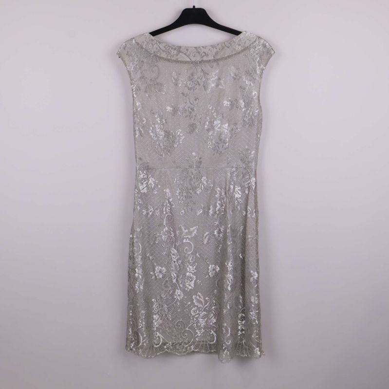 Silverfärgad spetsklänning sedd bakifrån på galge