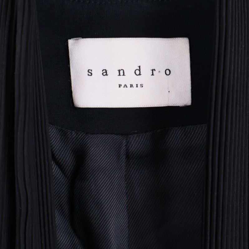 Närbild på Sandro Paris-märket i kavajen