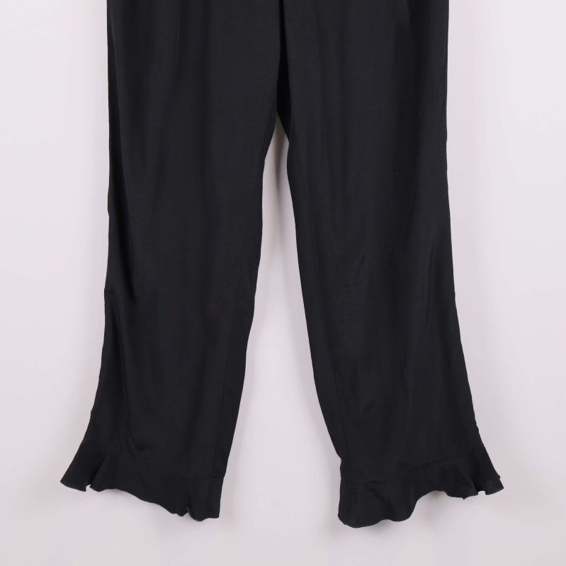 Volangdetaljer i nederkant på svarta vida byxor