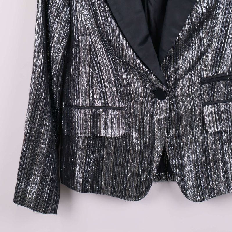 Närbild på kavajens glittrande tyg och strukturer