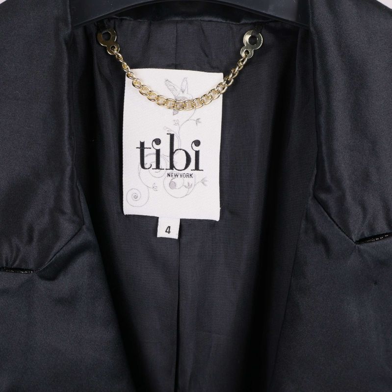 Närbild på tibi-etikett i kavajens krage