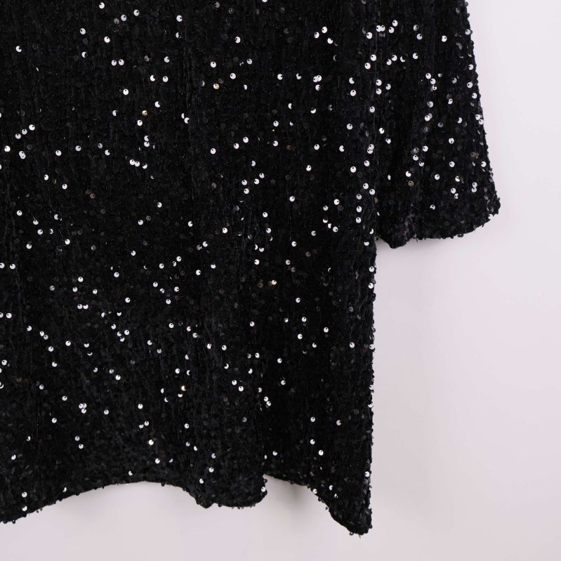 Detaljbild av paljetter på klänningens tyg