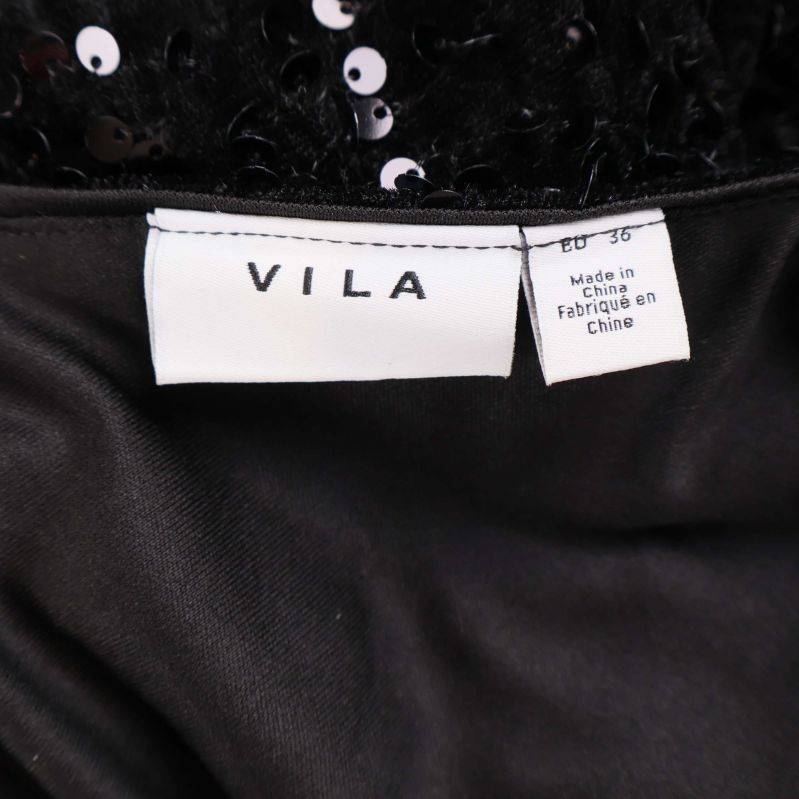 Närbild på vit etikett med texten VILA och storlek EU 36