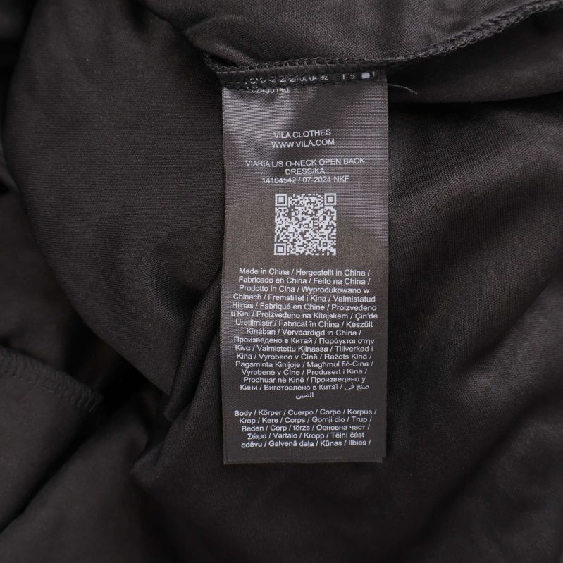 Materialetikett med detaljerad information på insidan av klänningen