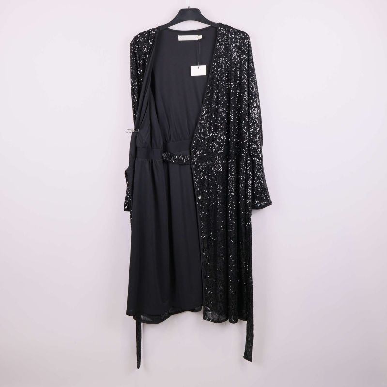 Insida av svart paljettklänning med öppnad omlott