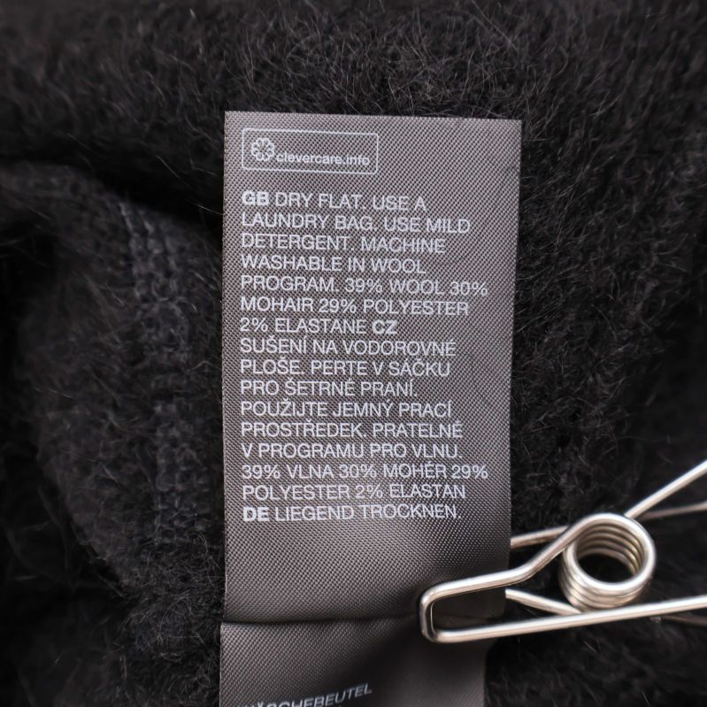 Materialetikett på svart tröja med sammansättning och tvättråd