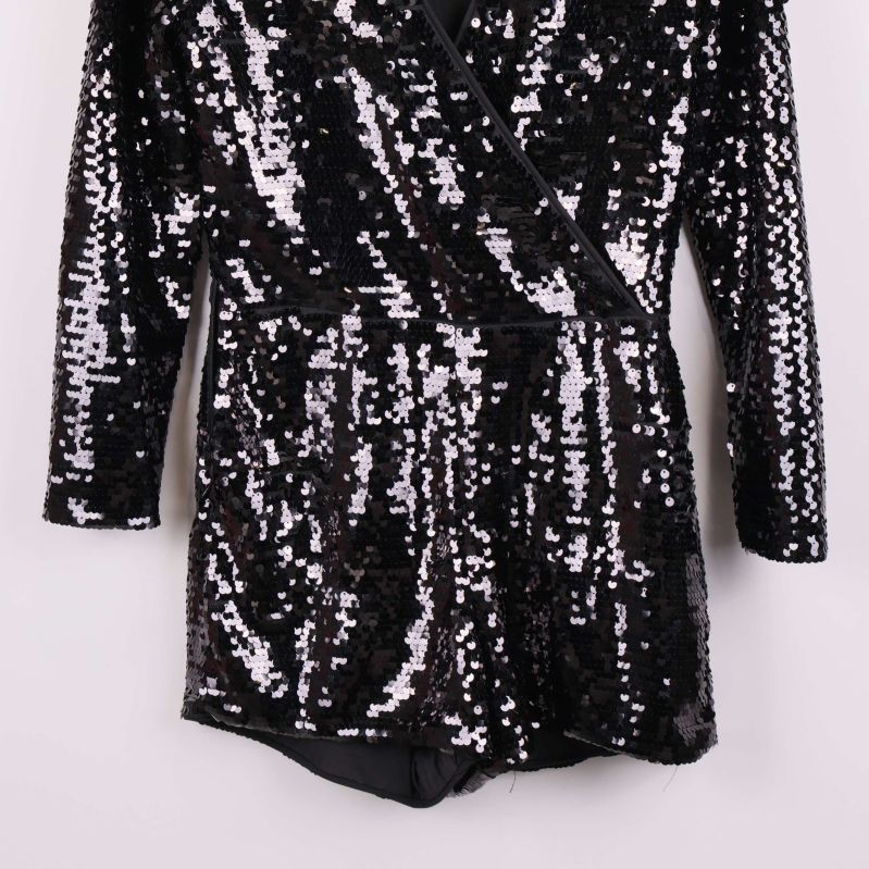 Nedre delen av jumpsuiten med paljettglans och ben i fokus