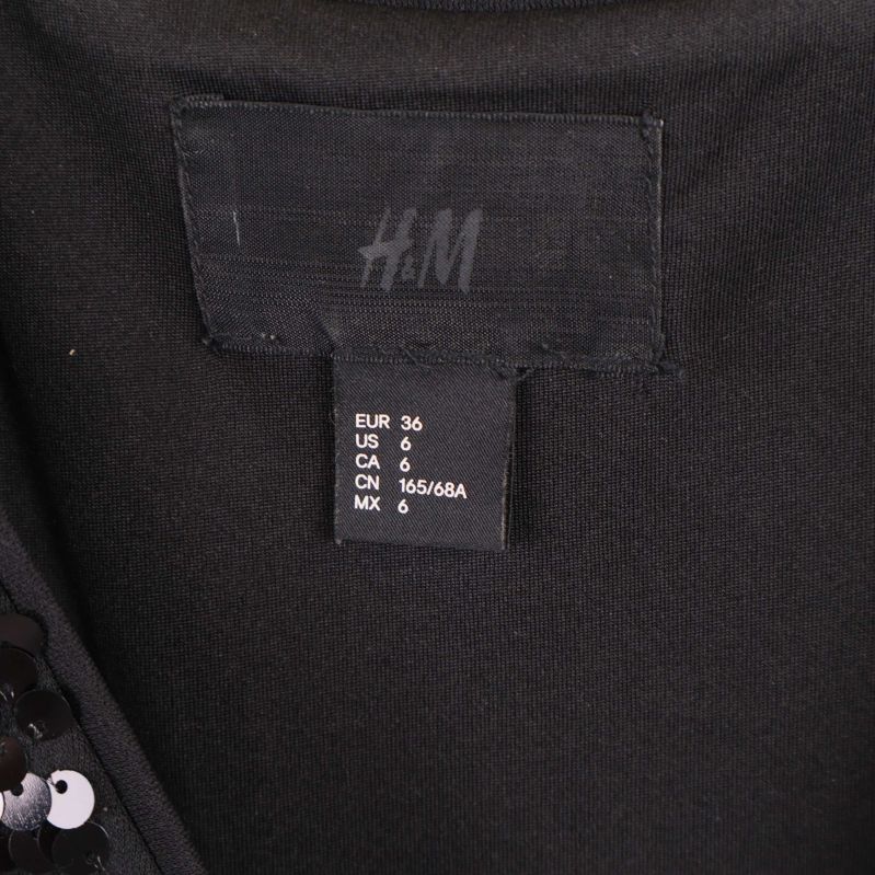 Närbild på H&M etikett med storleksangivelse inuti jumpsuiten