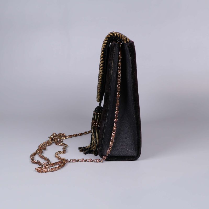 Sidovy av svart väska med kedja och tofs