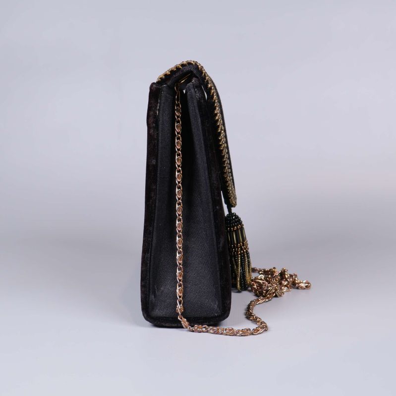 Sidovy från andra hållet av svart väska med kedjerem