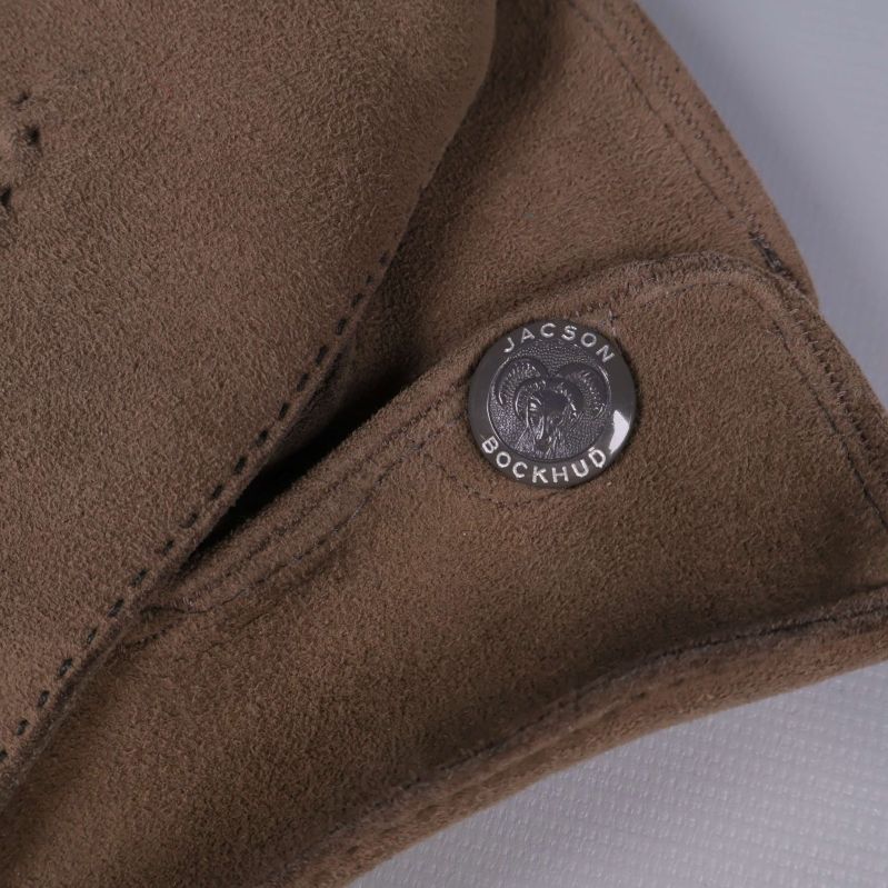 Närbild av metallknapp märkt Jacson Bockhus på handske