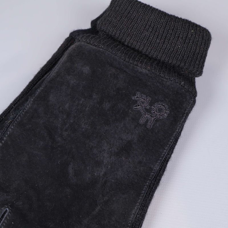 Närbild på mudd och broderad logotyp på handske