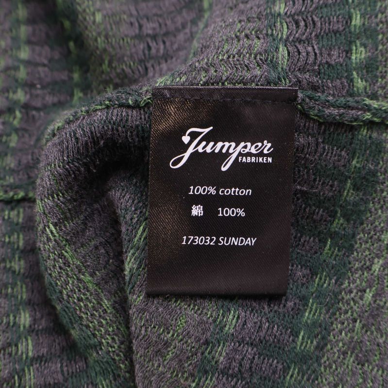 Materialetikett som visar 100% bomull från Jumperfabriken