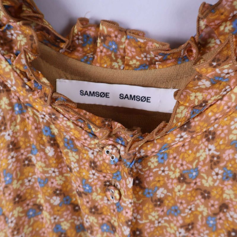 Närbild av Samsøe Samsøe-etikett i nacken på klänningen