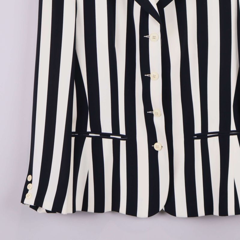 Nedre del av kavaj visar knappar och fickor