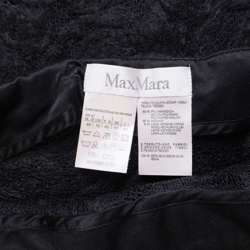 Närbild av Max Mara etikett och materialinformation i kjolen