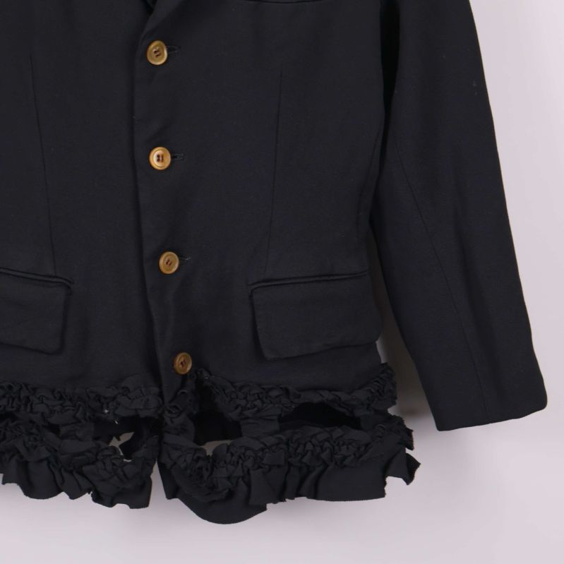 Detaljbild av höger ärm och volangkant på kavaj