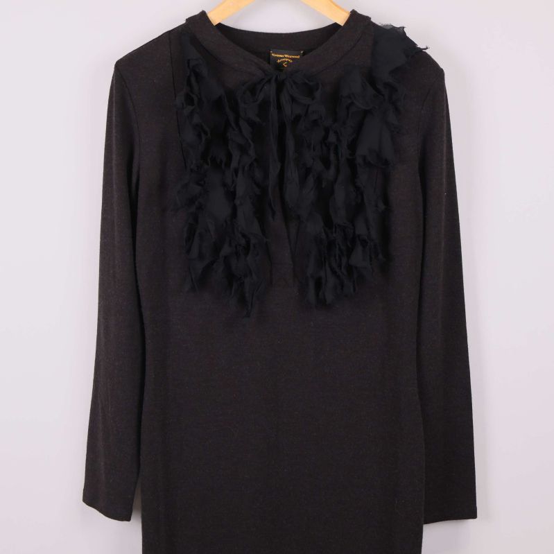 Framsidan av svart klänning med dekorativa applikationer