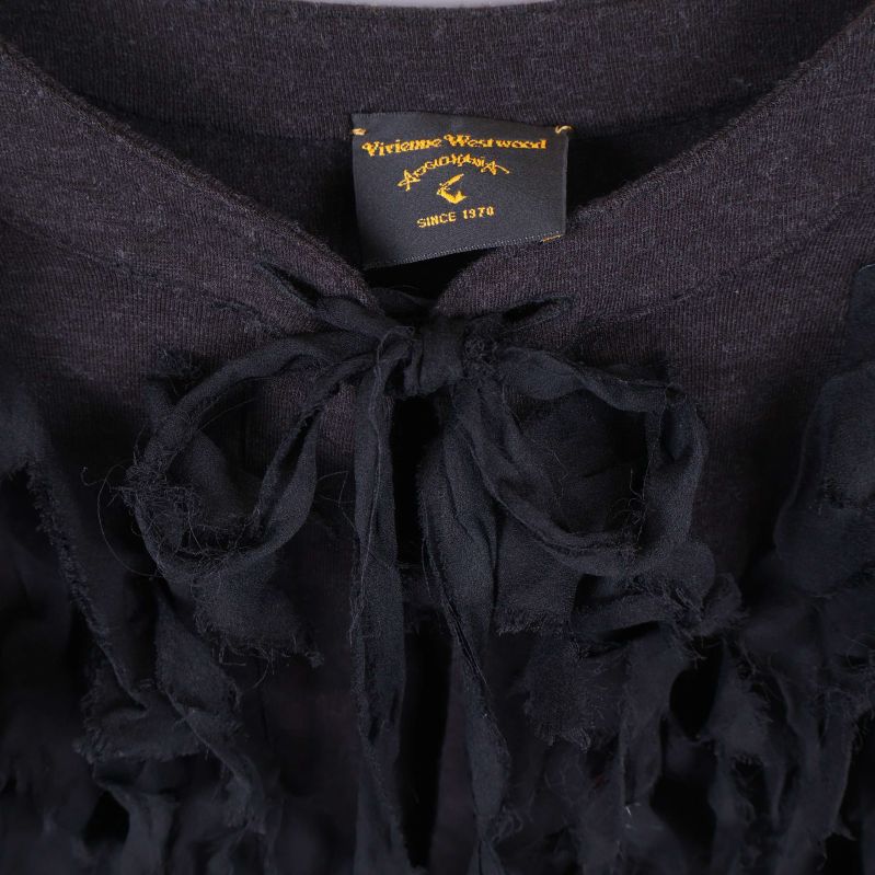 Närbild på logotyp och fransar vid halsringning