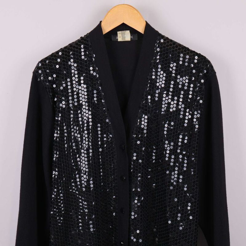 Övre delen av svart kofta med paljetter och djup V-ringning