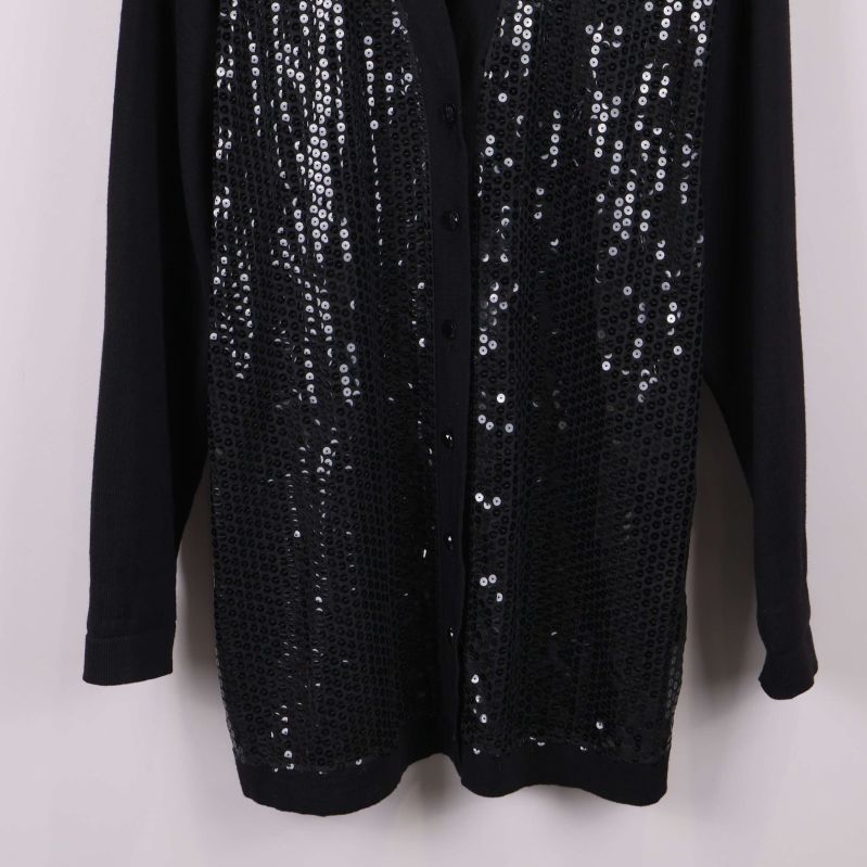 Nedre del av svart kofta med paljetter framtill