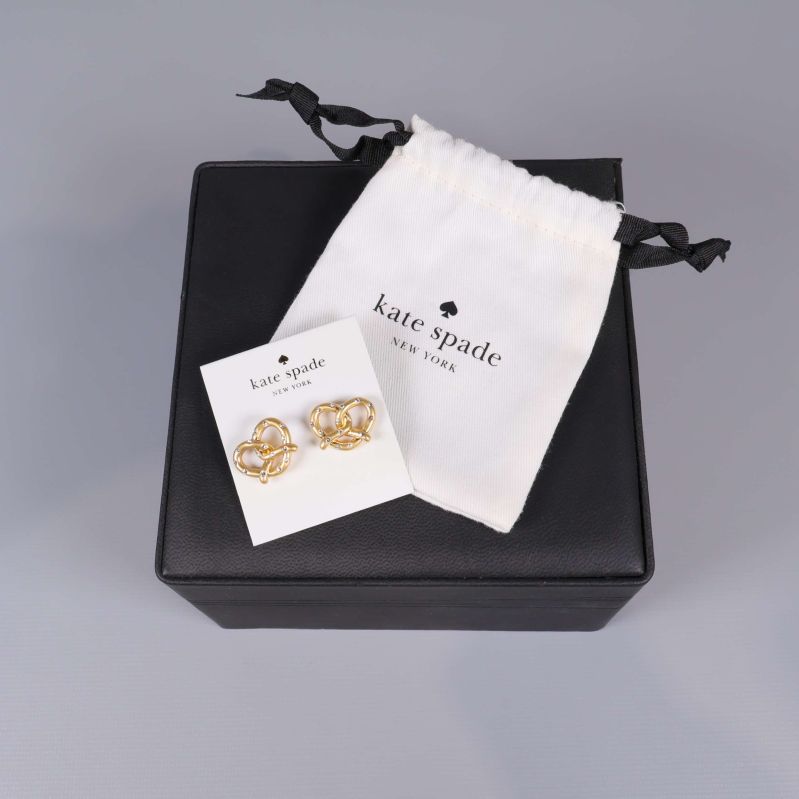 Guldfärgade hjärtformade örhängen på Kate Spade-kort med tygpåse