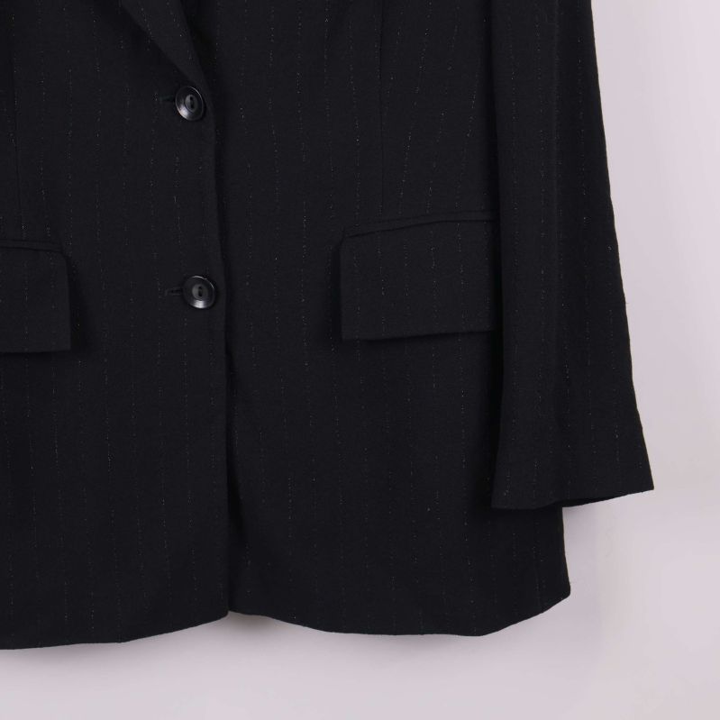 Nederkant av svart kavaj och ärmslut visas