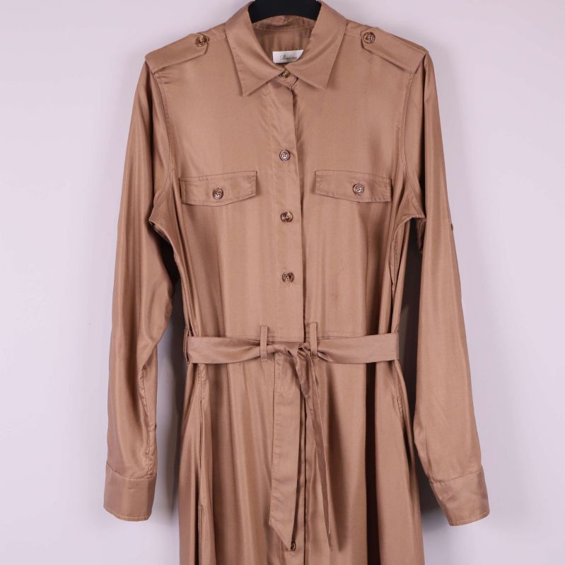 Detalj av skjortklänningens överdel med knappar och fickor