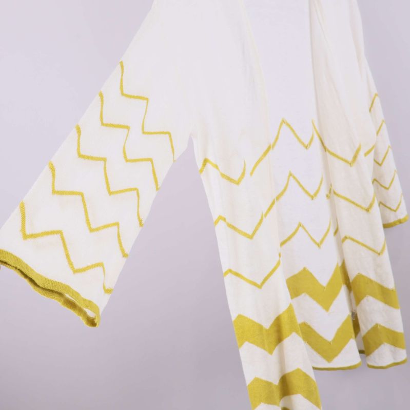 Närbild på ärm och gul zigzagdetalj på kofta