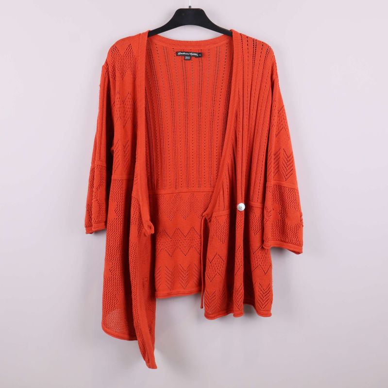 Orange stickad kofta öppen framtill på galge