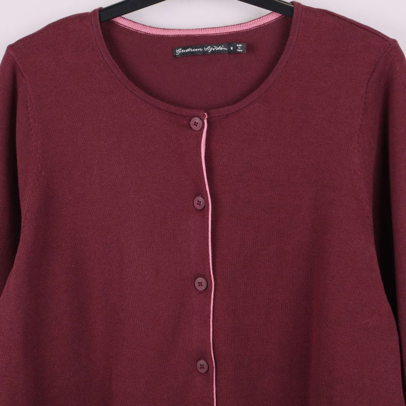 Detalj av knappslå och hals på vinröd kofta