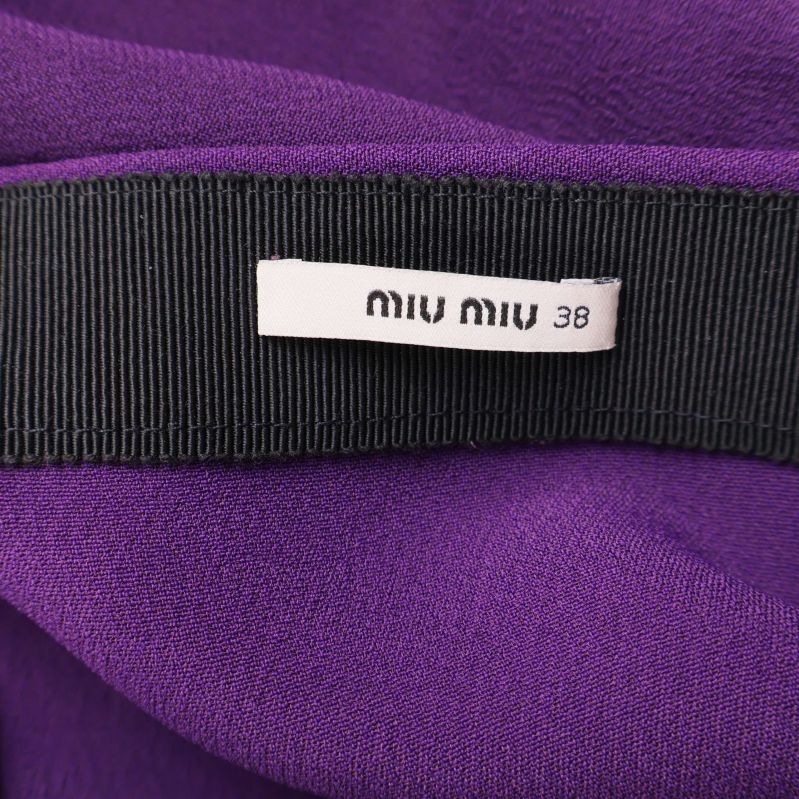 Närbild på Miu Miu-etikett fastsydd i kjolen