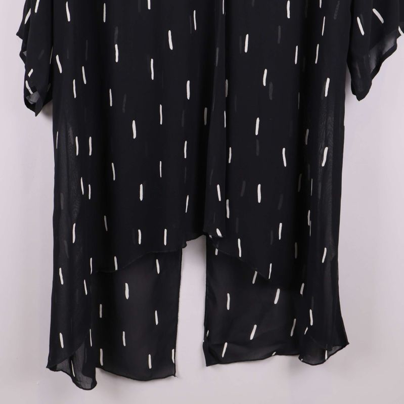 Närbild på nedre delen av den mönstrade tunikan