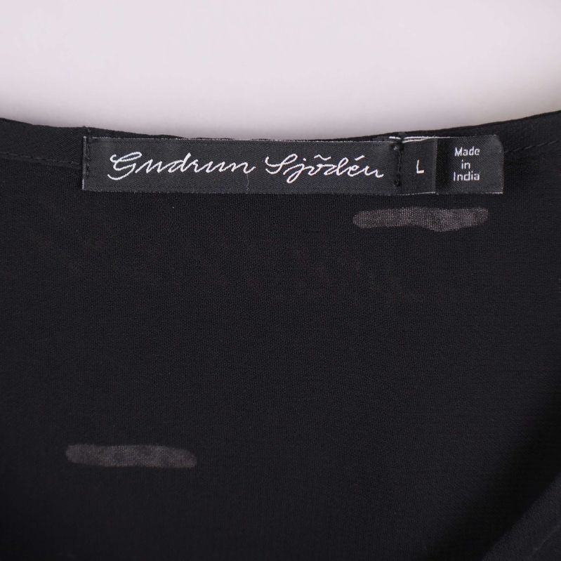 Nära bild på etikett från Gudrun Sjödén vid halsen