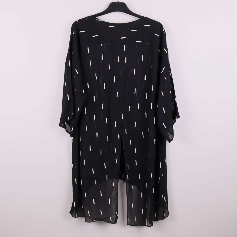 Baksidan av svart tunika med vitt mönster