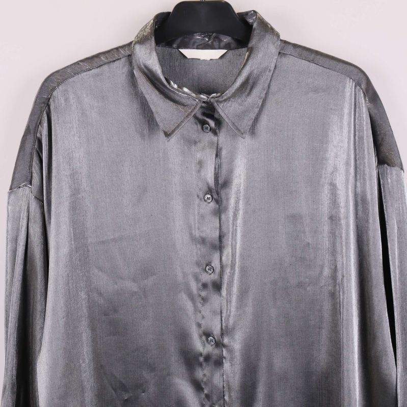 Närbild framtill av grå glansig skjorta med knappar