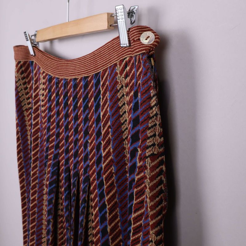 Sidoövre del av kjol med knapp och mönstrat tyg