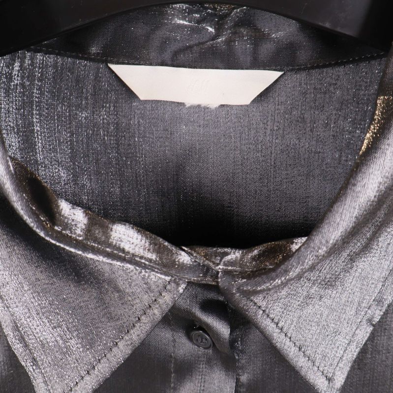 Närbild på krage och axelparti av glansig skjorta