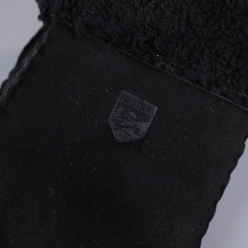 Närbild på präglad logga på svart tumvante