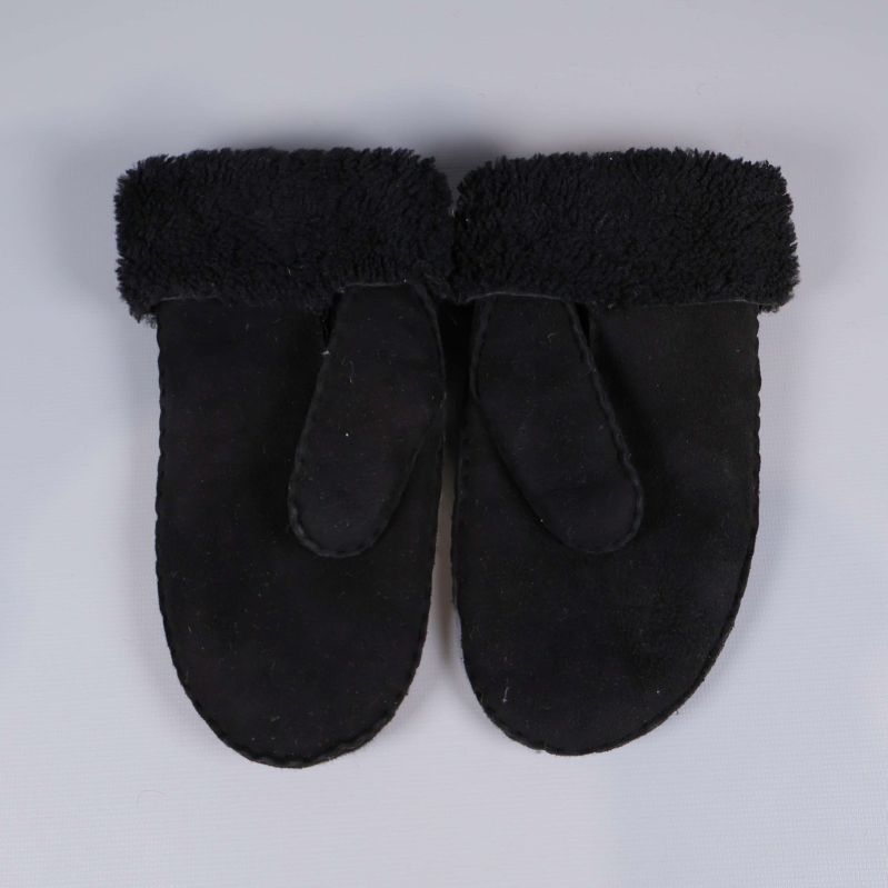 Baksida av svarta tumvantar i lammskinn och ull