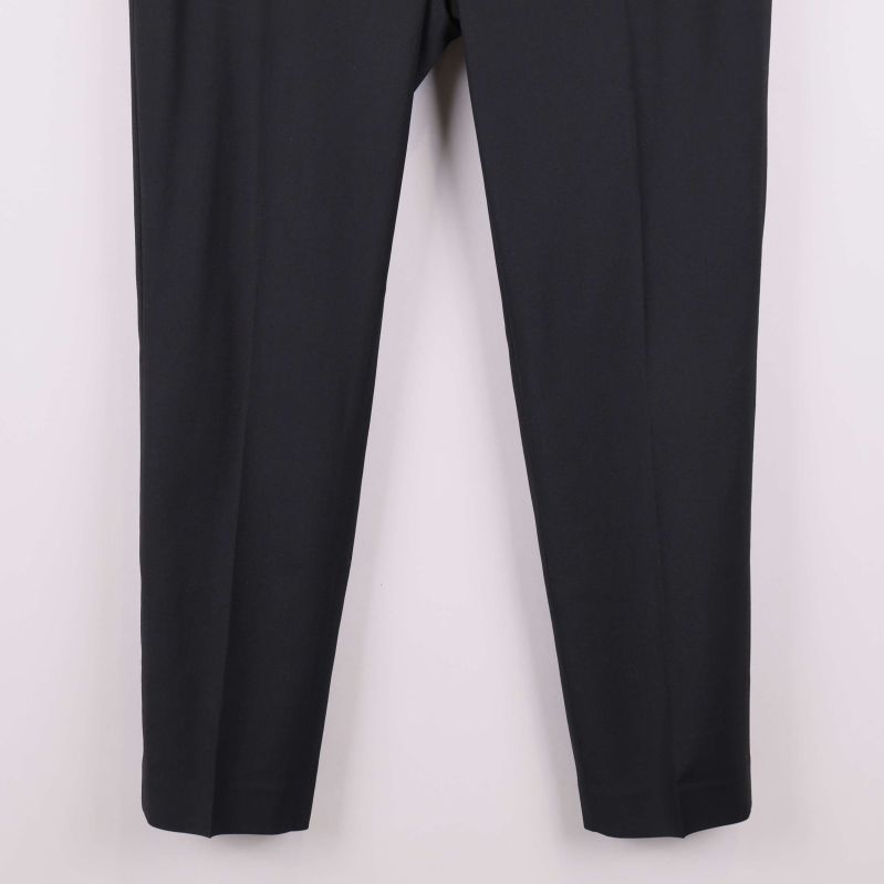 Närbild på benslut på svarta raka byxor