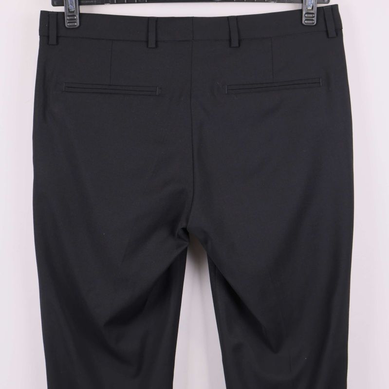 Närbild bakfickor på svarta raka byxor