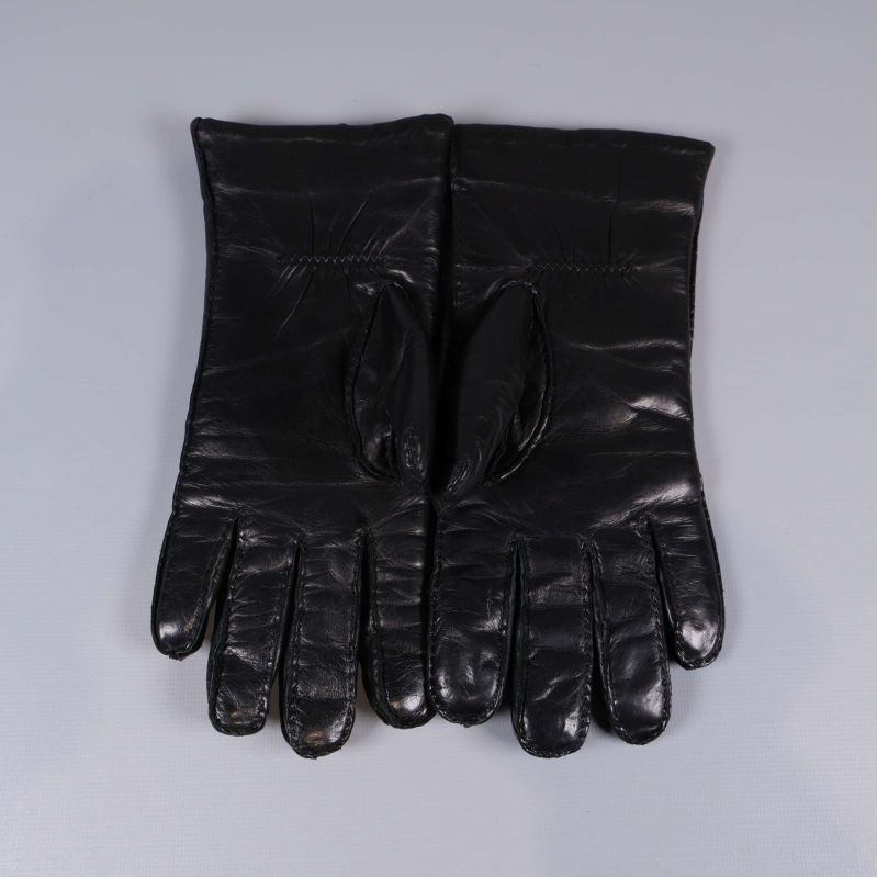 Båda svarta skinnhandskar placerade bredvid varandra