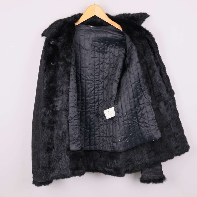 Jackan öppen visar quiltat svart innerfoder och päls