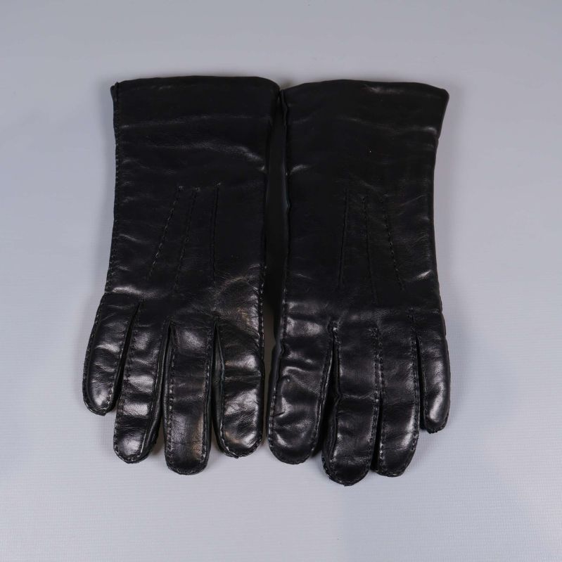 Framsidan av båda svarta skinnhandskar liggande