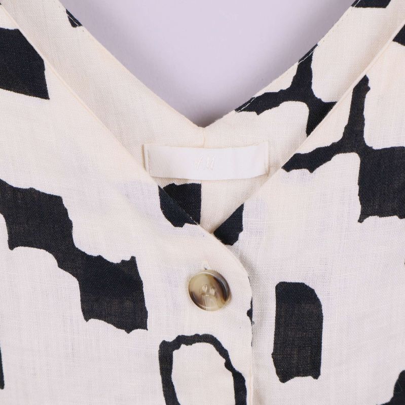 Närbild på v-ringning och knapp i framstycket