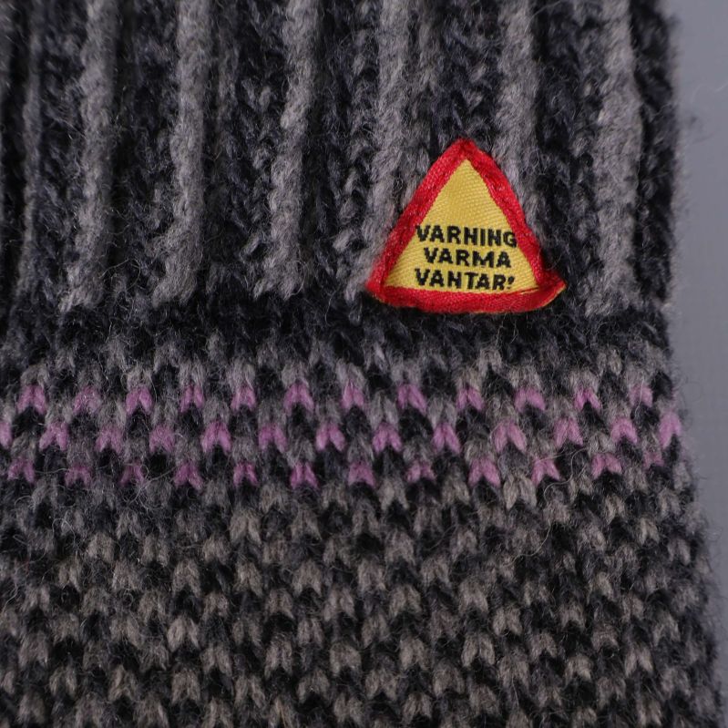 Närbild på varningsetikett med texten Varning varma vantar